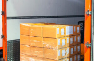 Cargo freight truck. Shipment, Delivery service. Logistics and transportation. Warehouse dock load pallet goods into shipping container truck. Stacked package boxes on pallet inside a truck.